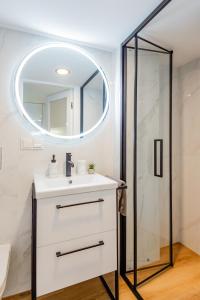 une salle de bain avec un lavabo et un miroir dans l'établissement Palanga Beach Apartments Daukanto, à Palanga