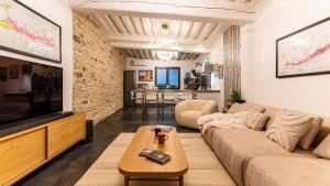 un soggiorno con un divano e una TV di La Maison Mercier a Digione