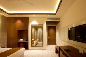 a hotel room with a bed and a tv and a bedroom at Ritz Resort Lucknow- The Perfect Blend of Business and Leisure in Lucknow