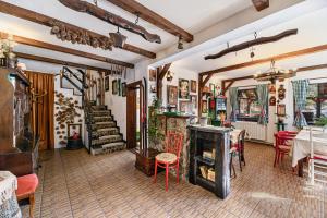 a room with a fireplace and a table and chairs at Casa cu Amintiri - Authentic Cozy Cottage in Bran