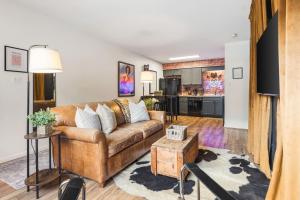 a living room with a couch and a kitchen at Cozy Condo by Music Row Walk to Restaurants and Bars in Nashville