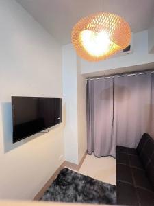 Unistay SHORE 3 Pool view w Balcony near MOA的电视和/或娱乐中心