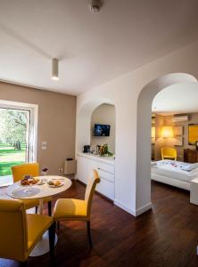 een woonkamer met een tafel en stoelen en een bed bij Quercia Belvedere Relais in Bardolino