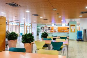 a cafeteria with tables and chairs and a kitchen at Akademie des Sports im LandesSportBund Niedersachsen in Hannover