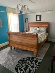 1 dormitorio con cama de madera y paredes azules en Poe Themed Home Close to Beaches and DE Turf, en Milford