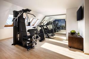a gym with tread machines and a mirror at NH Budapest City in Budapest +24 photos