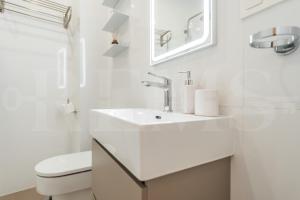 un bagno bianco con lavandino e WC di Artistic and Spacious Apartment by REMS a Málaga Altre 28 foto