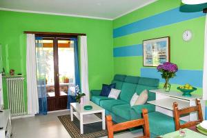 a living room with a blue couch and green walls at Piccola Oasi in Cannobio