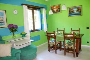 a living room with green walls and a table and chairs at Piccola Oasi in Cannobio