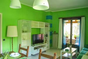 a living room with green walls and a television at Piccola Oasi in Cannobio