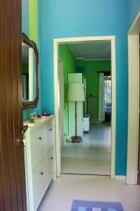 a room with green walls and a mirror and a lamp at Piccola Oasi in Cannobio