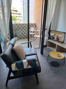 ein Wohnzimmer mit einem Stuhl und einem Tisch in der Unterkunft Grand Studio avec Parking et Wifi in Castelnau-le-Lez