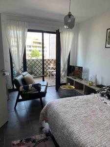 ein Schlafzimmer mit einem Bett und einem Stuhl und einem Fenster in der Unterkunft Grand Studio avec Parking et Wifi in Castelnau-le-Lez