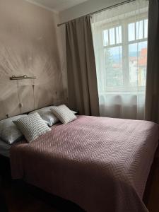 a bedroom with a large bed with a window at Apartament 19 Delux- Bliżej Zdroju in Polanica-Zdrój