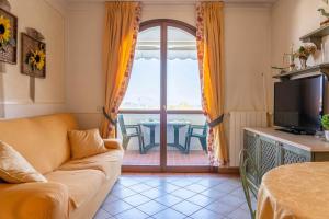 a living room with a couch and a view of a table at Appartamento La Quiete in Polpenazze del Garda