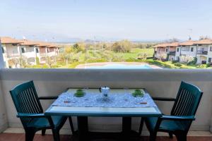 a blue table with two chairs and a view of a pool at Appartamento La Quiete in Polpenazze del Garda