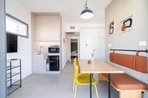 a kitchen and dining room with a table and yellow chairs at Urban Nest Yaavetz Tlv in Tel Aviv