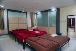 a bedroom with two beds with red pillows at Green Villa Bukit Tinggi#event house#karaokeroom#swimmingpool in Klang +40 photos