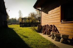 a building with wooden wheels next to a fence at Sołtysówka in Wólka Nadbużna