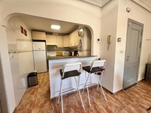 una cucina con bancone e due sgabelli di Playa en La Cumbre a Puerto de Mazarrón