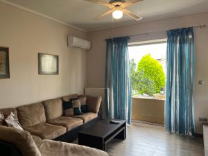 un soggiorno con un divano e una grande finestra di Christina garden maisonette Flogita a Flogita