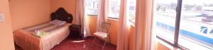 a small bedroom with a bed and a window at Hostal Lesly Salomé in Tulcán