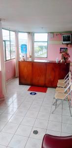 a living room with a desk and a red chair at Hostal Lesly Salomé in Tulcán +37 photos