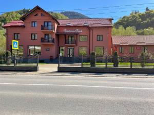 a building with a fence in front of a street at Pensiunea Doris in Rodna