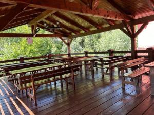 een groep tafels en banken op een houten terras bij Pensiunea Doris in Rodna