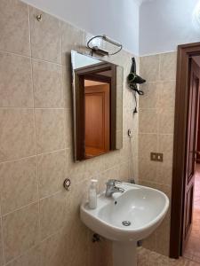 une salle de bain avec un lavabo et un miroir dans l'établissement Castagna Apartment, à Bellagio 15 autres photos