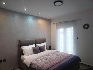 a bedroom with a bed with pillows and a window at ViS APARTMAN in Trebinje
