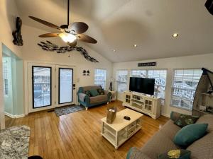 Una sala de estar con un sofá y un televisor de pantalla plana. en Ocean Lakes Golf Cart Pet Friendly 1648, en Myrtle Beach