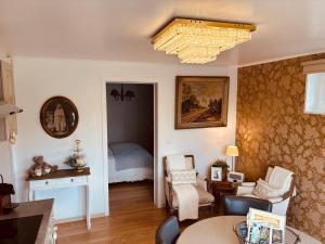 a living room with a bed and a chandelier at Au refuge du spéléo in Hotton