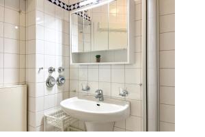 a white bathroom with a sink and a mirror at Goosbrink Wohnung 13 in Boltenhagen +29 photos