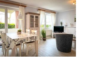 a dining room with a table and chairs and a television at Goosbrink Wohnung 13 in Boltenhagen