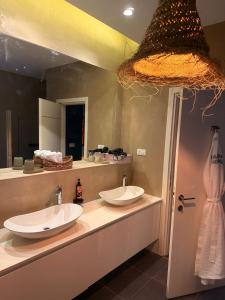une salle de bain avec deux lavabos et un grand miroir dans l'établissement Lady Balfour by Villa Balfour Eilat, à Eilat