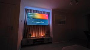 a tv in a room with a fireplace with candles at 3 Bed Home - Sleeps 8 - Stoke City fc - Parking in Stoke on Trent +7 photos