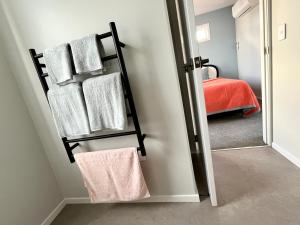 a bathroom with a towel rack and a bed at Brand new Lakeside cozy room Hoiho in Taupo
