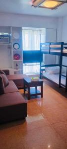 een woonkamer met een bank en een stapelbed bij Avida sm sucat condotel in Manilla +21 foto's