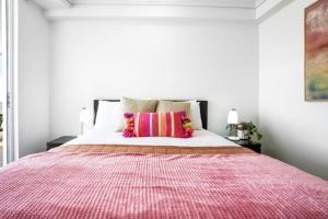 a bedroom with a large bed with a red blanket at Cairns Central Apartment 1011 in Cairns +7 photos