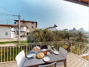 una mesa con comida en la parte superior de un balcón en Pinko House By Bookinggardalake, en Manerba del Garda