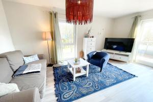 un salon avec un canapé et une télévision dans l'établissement Strandstrasse 21 Ferienwohnung Domizil Auszeit, à Kolpinsee