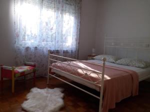 a bedroom with a bed and a window with curtains at Apartman Sara in Pula