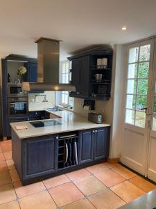 a kitchen with dark wood cabinets and a counter top at VILLA BIARRITZ 1923 private pool in Biarritz