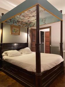 a bedroom with a canopy bed with a flowery ceiling at VILLA BIARRITZ 1923 private pool in Biarritz +36 photos
