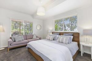 a bedroom with a large bed and a couch at Bimbadeen Luxurious Retreat in Aireys Inlet