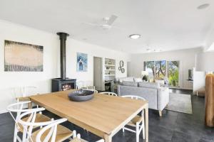 a living room with a wooden table and a fireplace at Bimbadeen Luxurious Retreat in Aireys Inlet