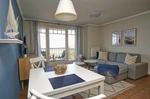ein Wohnzimmer mit Sofa und Tisch in der Unterkunft Ferienwohnung mit traumhaftem Meerblick - Haus am Meer FeWo 03 in Lohme