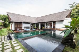 a house with a swimming pool in front of it at Villa More Bali in Uluwatu