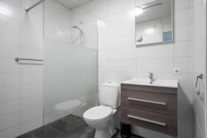a bathroom with a toilet and a sink and a shower at Beach Appartement 14 - Aan de duinen, Callantsoog aan Zee in Callantsoog